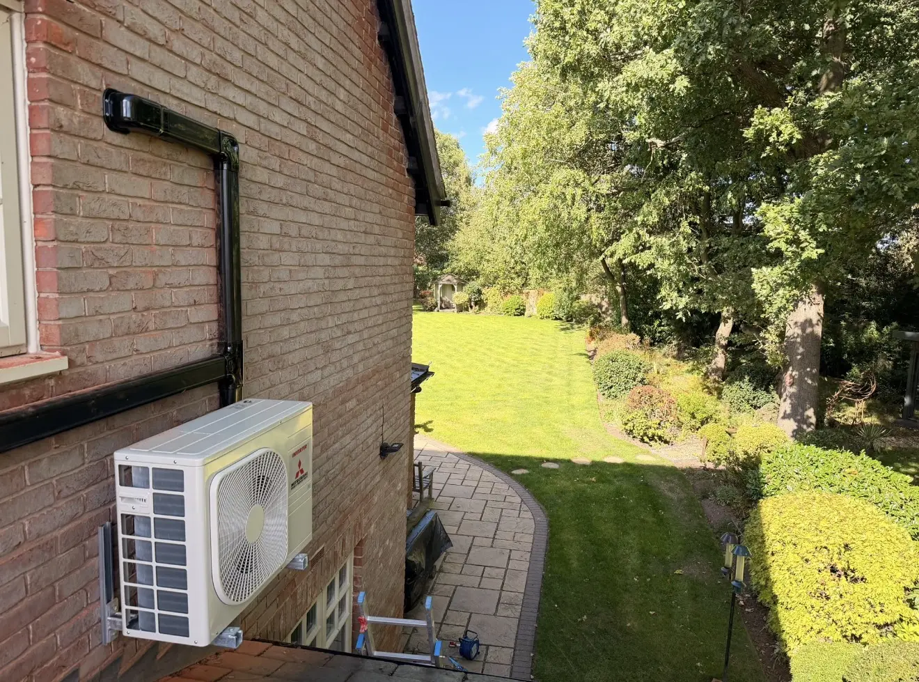 Air conditioning outdoor unit on a gable wall with neat black trunking