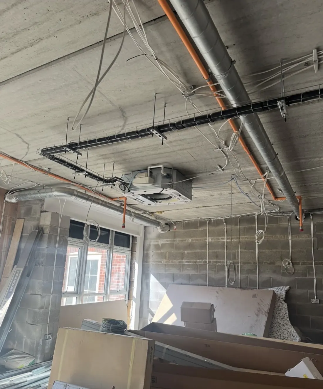 Ceiling cassette installed under a concrete soffit with drop-rods, tray and containment