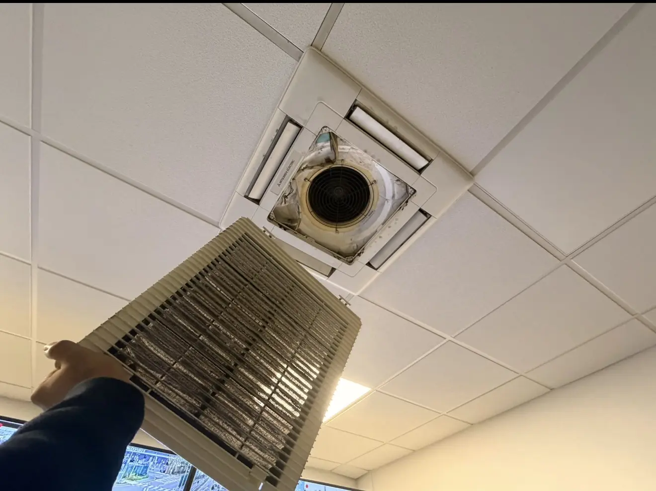 Ceiling cassette filter removed for cleaning during an air conditioning service