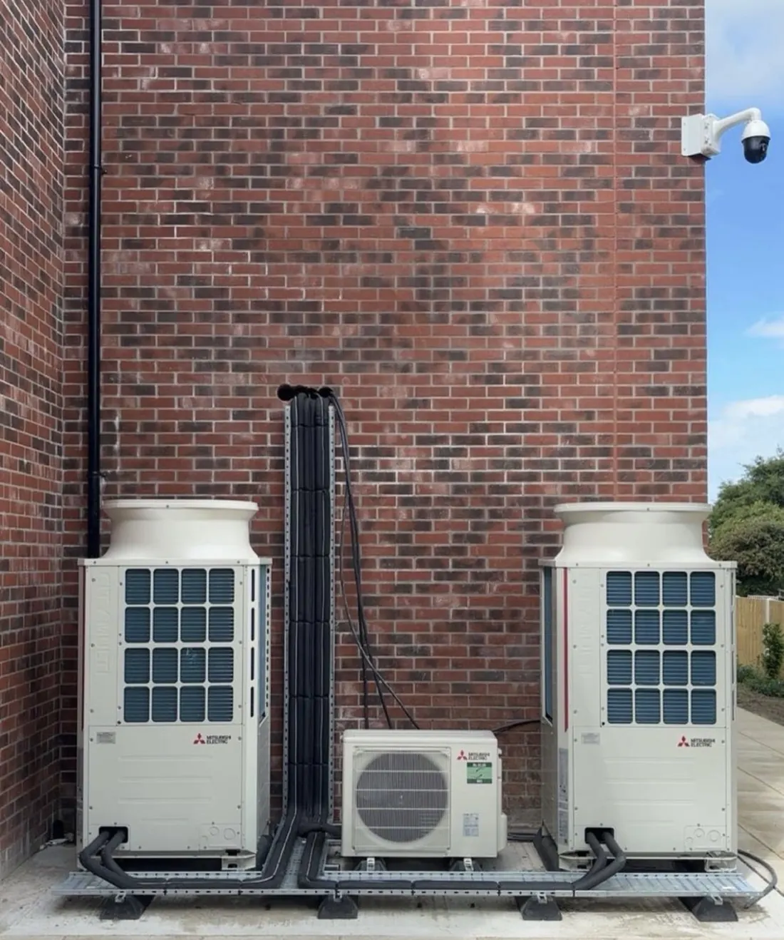 Twin City Multi VRF outdoor units either side of a riser with a split unit between them