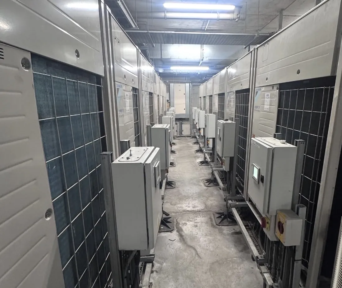 Row of Daikin VRV outdoor units in a commercial plant room with isolators and controls