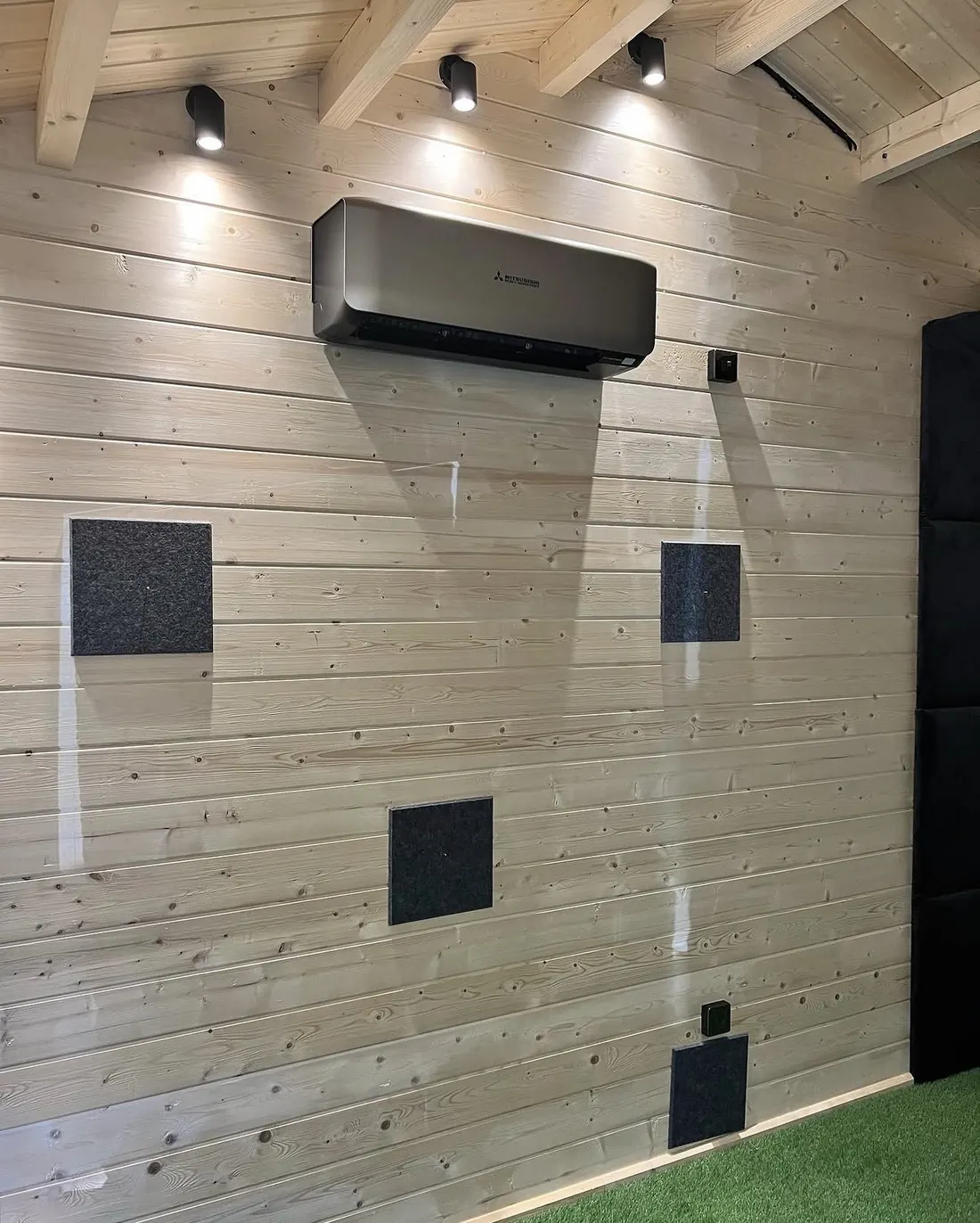 Black Mitsubishi Heavy Industries wall unit in a timber garden room