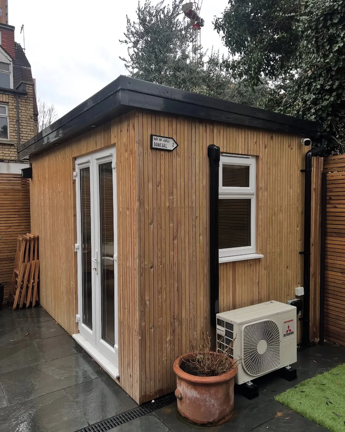 Timber garden room with a Mitsubishi outdoor unit on anti-vibration feet