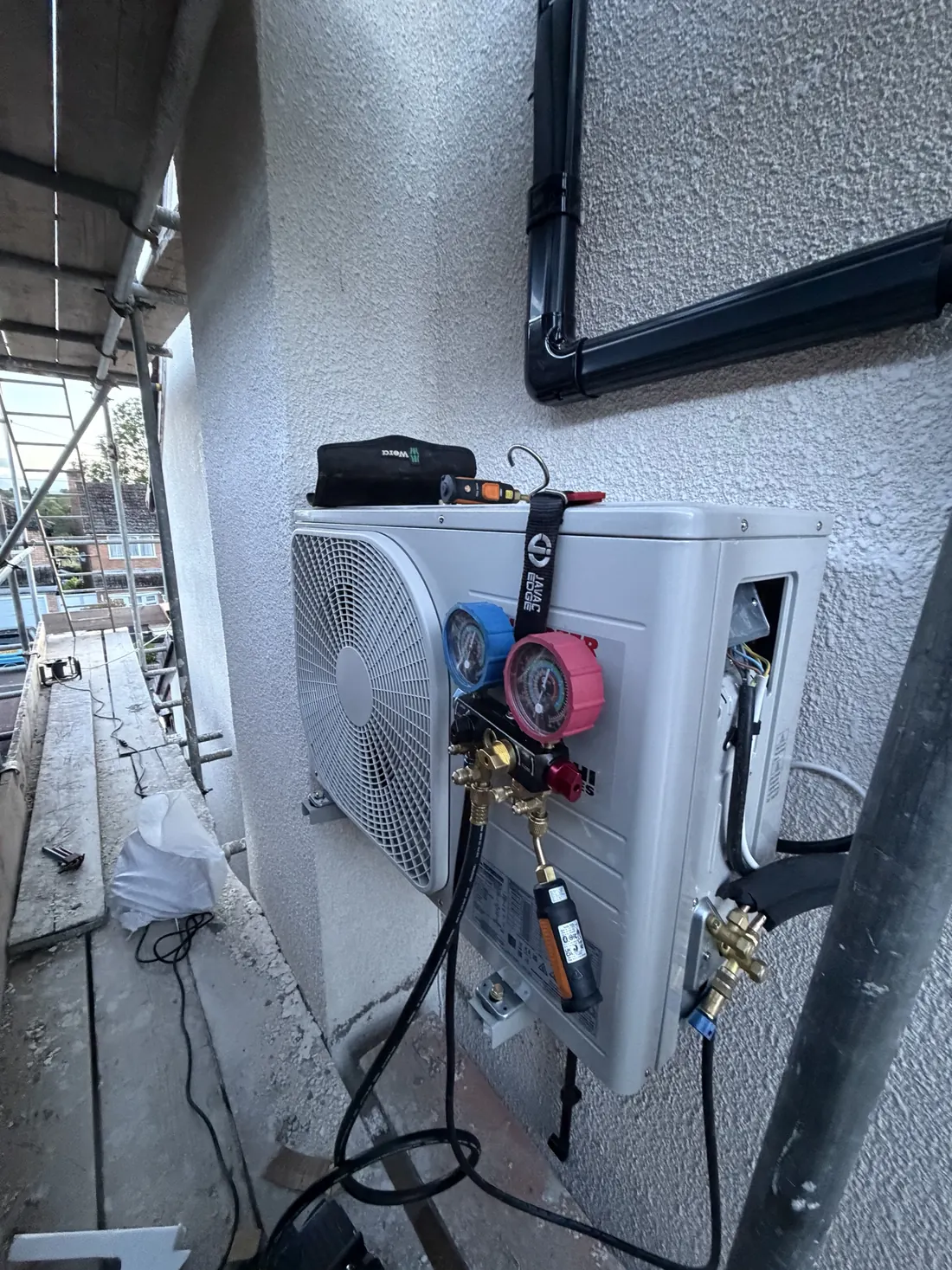 Engineer’s manifold gauges connected to an outdoor unit during commissioning
