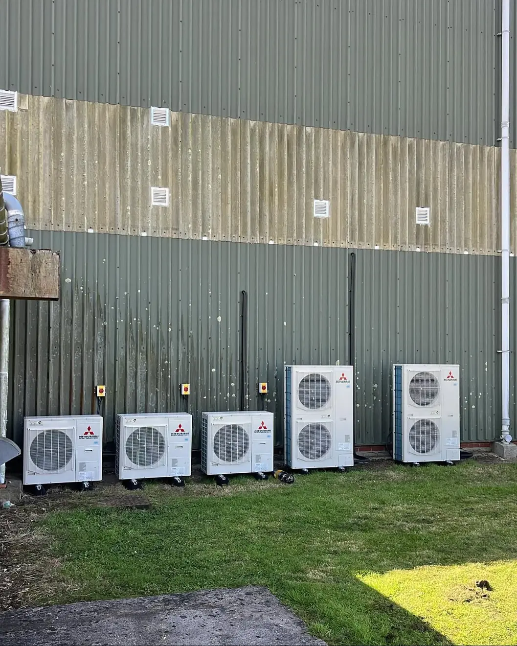Five Mitsubishi Heavy Industries outdoor units installed beside an industrial building