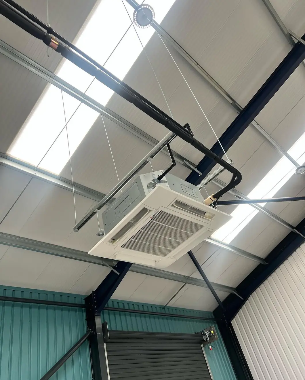 Ceiling cassette suspended in a warehouse with insulated refrigerant pipework