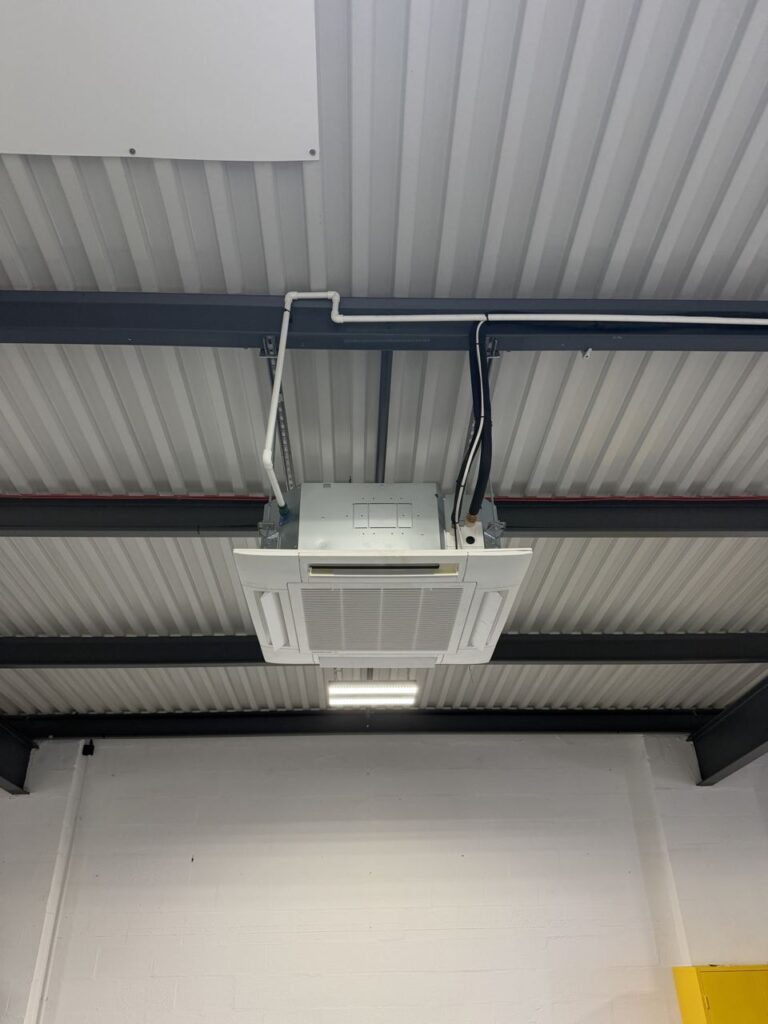 A cassette hung from the steel framework with pipework run along the beams